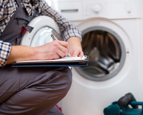 Man kneeling next to dryer inspection